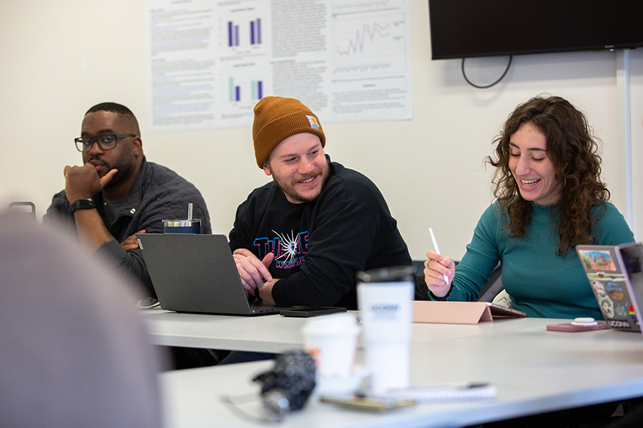 Students smiling during a graduate communication class.