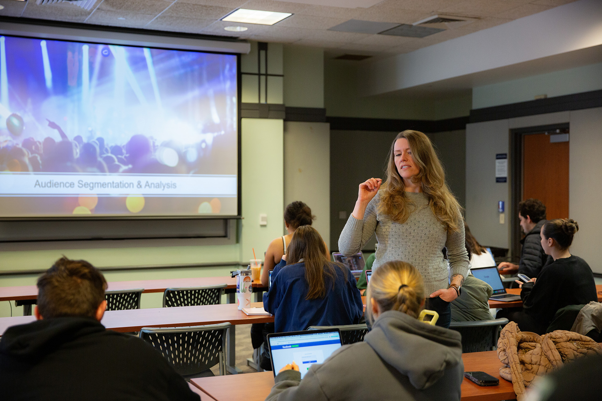 A professor stands in front of a class with the words "Audience Segmentation and Analysis" on the projection screen.